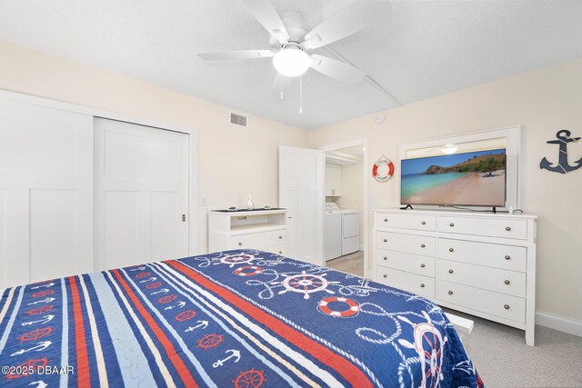 3807 S Atlantic Ave Unit 203, Daytona Beach, FL 32118 - bedroom with washing machine and dryer, a closet, a ceiling fan, light colored carpet, and baseboards
