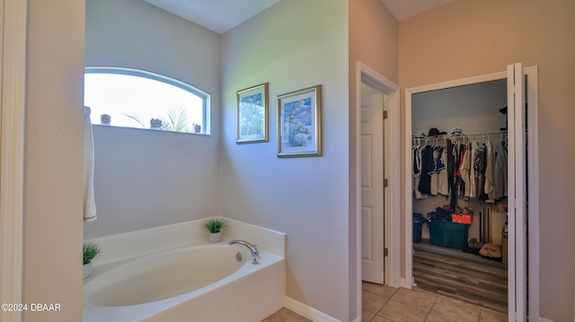 bathroom with a bathing tub and tile patterned flooring