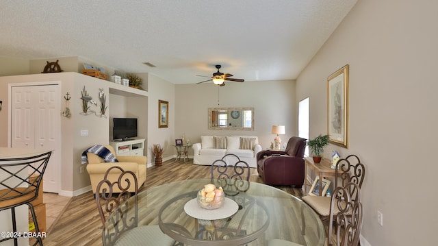 dining room with a textured ceiling, hardwood / wood-style flooring, and ceiling fan