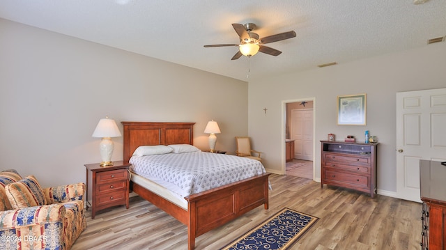 bedroom with ensuite bath, ceiling fan, a textured ceiling, and light wood-type flooring