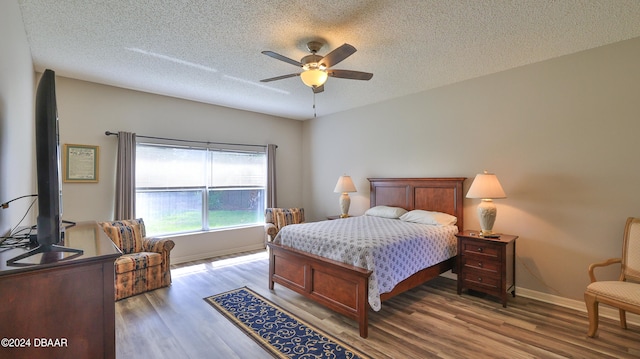 bedroom featuring wood-type flooring, ceiling fan, and a textured ceiling