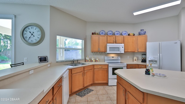 kitchen featuring light tile patterned floors, white appliances, plenty of natural light, and sink