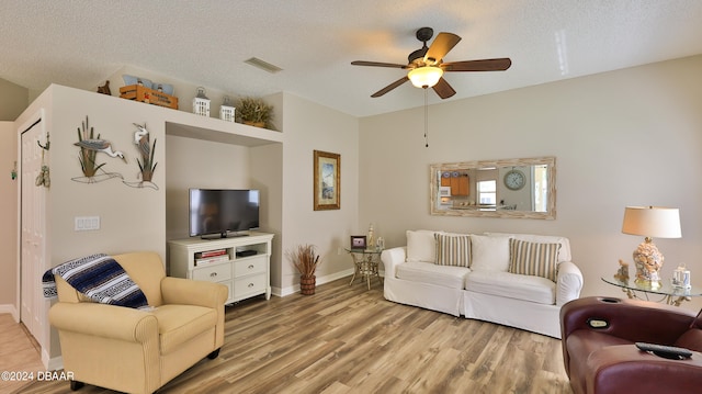 living room with hardwood / wood-style floors, a textured ceiling, and ceiling fan