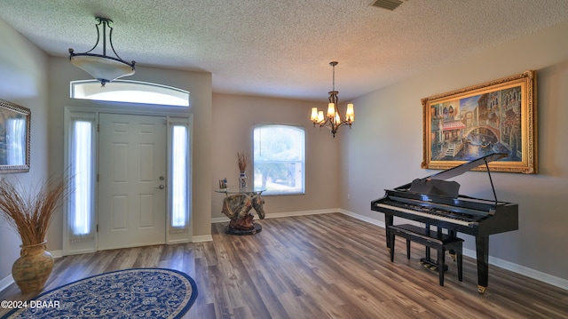 entryway featuring an inviting chandelier, hardwood / wood-style floors, and a textured ceiling