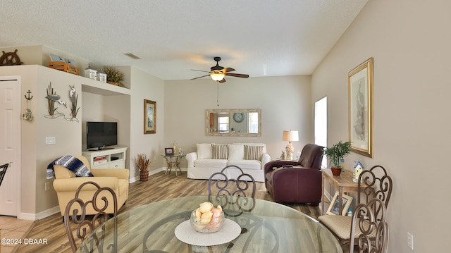 living room with wood-type flooring, ceiling fan, and a textured ceiling