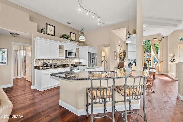 kitchen featuring a kitchen breakfast bar, stainless steel appliances, dark wood-type flooring, sink, and white cabinetry