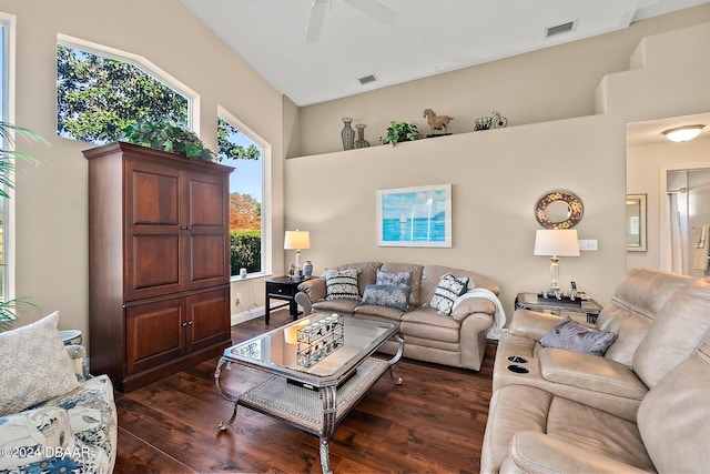 living room with ceiling fan, dark wood-type flooring, and a high ceiling