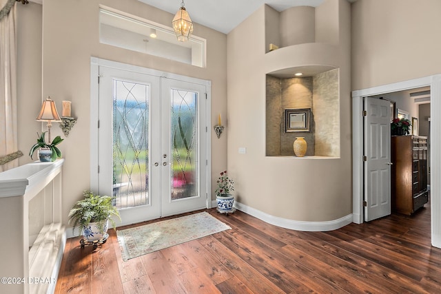 foyer with french doors, dark wood-type flooring, and a high ceiling