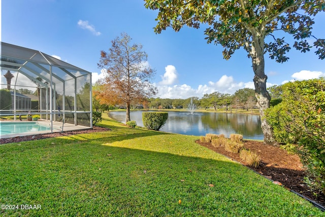 view of yard featuring a lanai and a water view