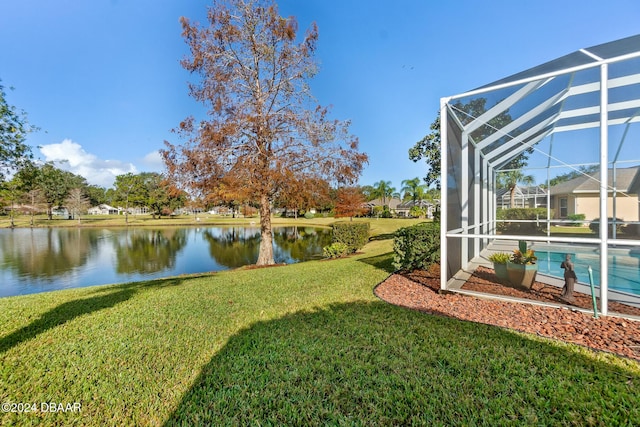 view of yard with glass enclosure and a water view