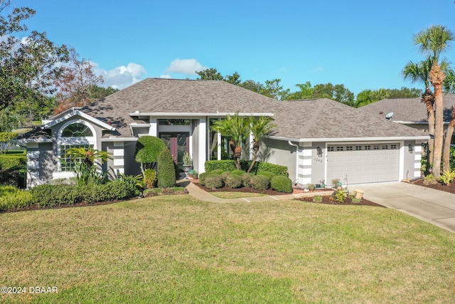 view of front of house with a garage and a front lawn