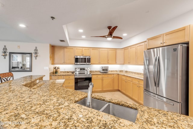 kitchen featuring light stone counters, sink, ceiling fan, light brown cabinets, and appliances with stainless steel finishes