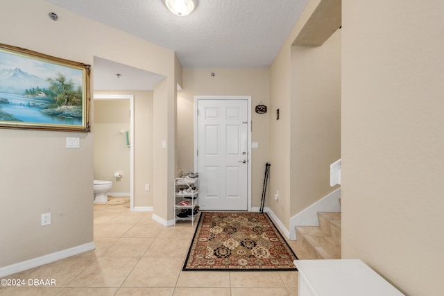 tiled entrance foyer featuring a textured ceiling