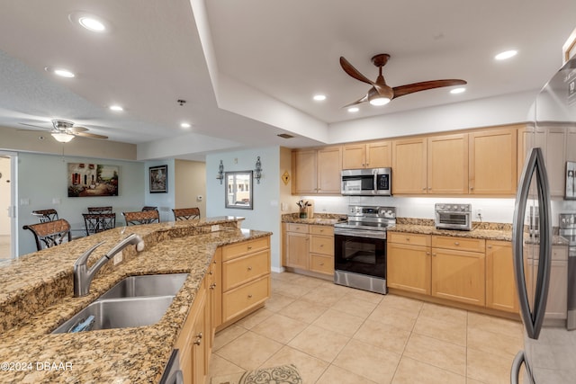 kitchen featuring light brown cabinets, sink, light stone counters, and stainless steel appliances