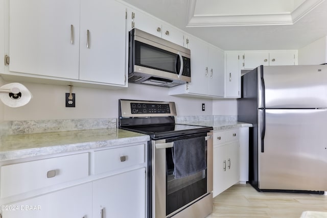 kitchen featuring stainless steel appliances, white cabinets, and light wood-type flooring