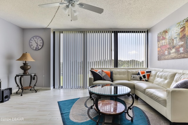 living room featuring a textured ceiling, ceiling fan, and wood-type flooring