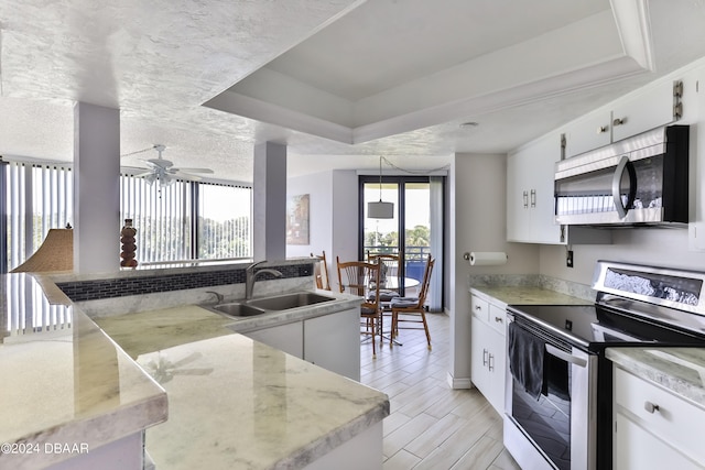 kitchen with white cabinets, sink, ceiling fan, and stainless steel appliances