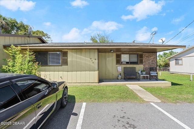 view of front of home featuring uncovered parking and a front yard