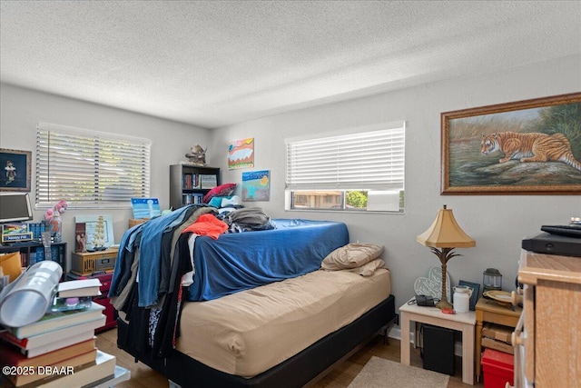 bedroom featuring a textured ceiling and wood finished floors