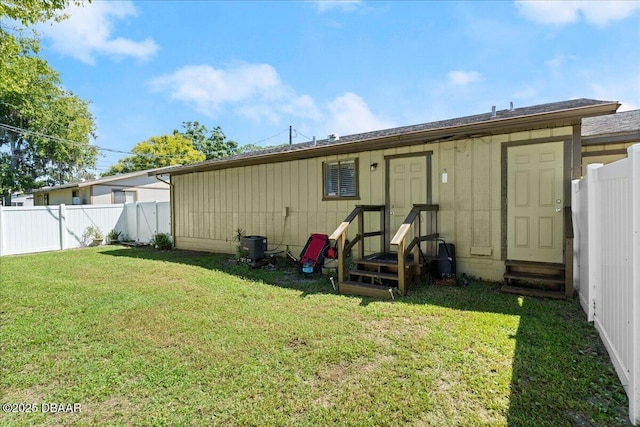 back of property featuring a lawn and a fenced backyard