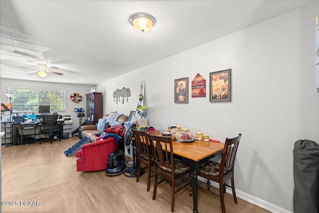 dining area featuring a textured ceiling, a ceiling fan, and wood finished floors