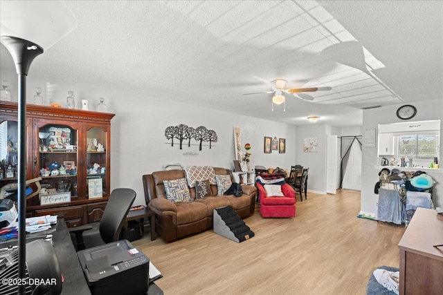 interior space with a ceiling fan, light wood-style flooring, and a textured ceiling