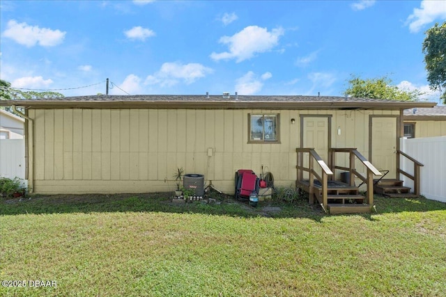 back of house featuring a lawn and fence