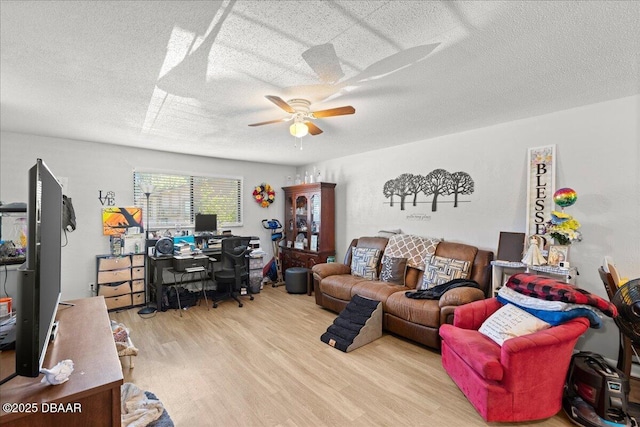 living room featuring ceiling fan, a textured ceiling, and wood finished floors