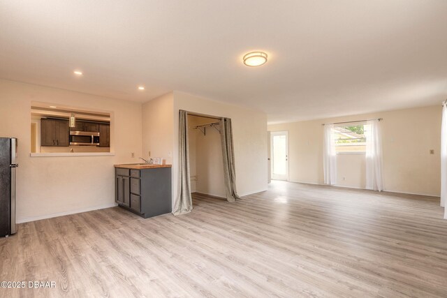 73 N St Andrews Dr, Ormond Beach, FL 32174 - unfurnished living room featuring light wood-style flooring, recessed lighting, and baseboards