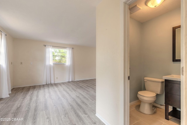 73 N St Andrews Dr, Ormond Beach, FL 32174 - bathroom featuring vanity, wood finished floors, toilet, and baseboards