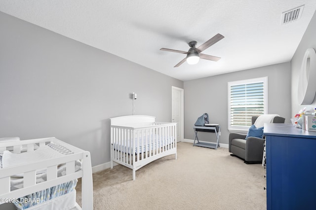 bedroom featuring light carpet, baseboards, visible vents, and ceiling fan