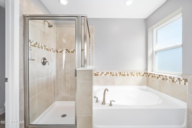 bathroom with a garden tub, a shower stall, and recessed lighting