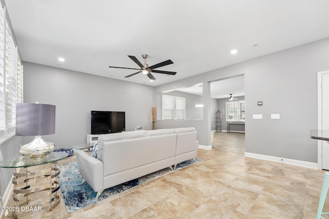 living area with recessed lighting, ceiling fan, and baseboards