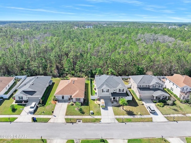 birds eye view of property featuring a residential view and a wooded view