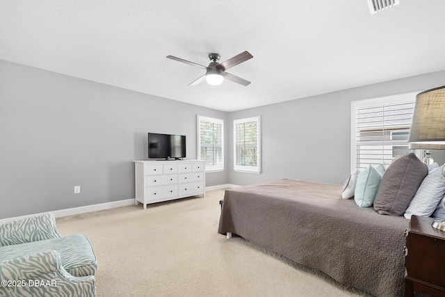 bedroom featuring a ceiling fan, light colored carpet, visible vents, and baseboards