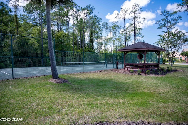 view of community with a tennis court, fence, a lawn, and a gazebo