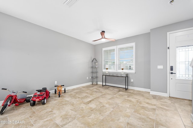 misc room with baseboards, visible vents, and a ceiling fan