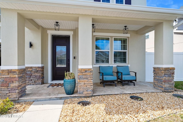 property entrance with stone siding and a porch