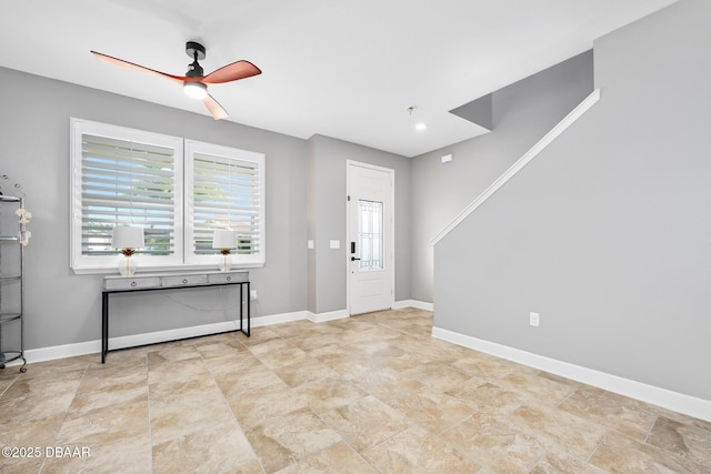 unfurnished room with ceiling fan and baseboards