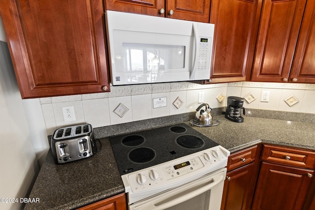 200 Ocean Crest Dr Unit 705, Palm Coast, FL 32137 - kitchen featuring white appliances, tasteful backsplash, and dark stone counters