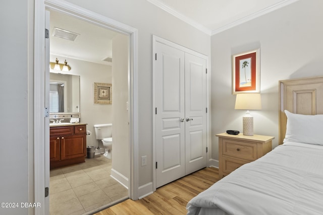 200 Ocean Crest Dr Unit 705, Palm Coast, FL 32137 - bedroom with ornamental molding, a closet, light wood-style flooring, and connected bathroom