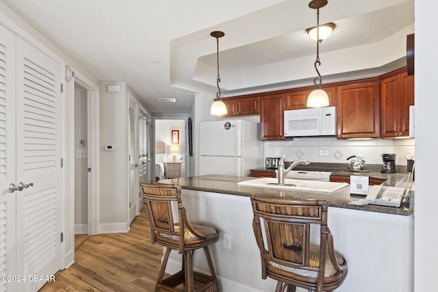 200 Ocean Crest Dr Unit 705, Palm Coast, FL 32137 - kitchen featuring white appliances, light wood-style floors, backsplash, a breakfast bar, and pendant lighting