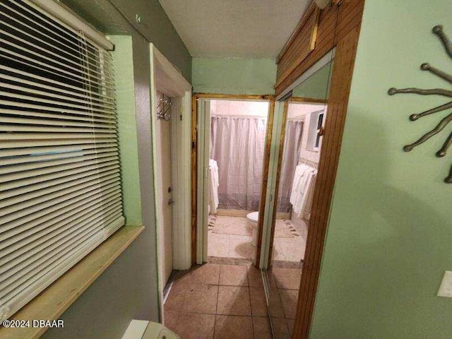 hall featuring light tile patterned floors