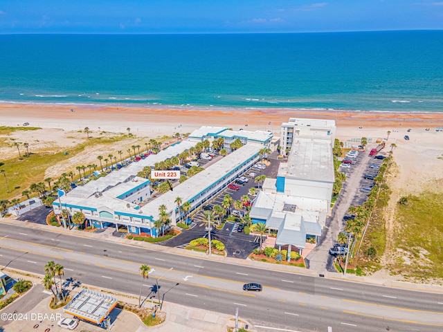 birds eye view of property with a water view and a beach view