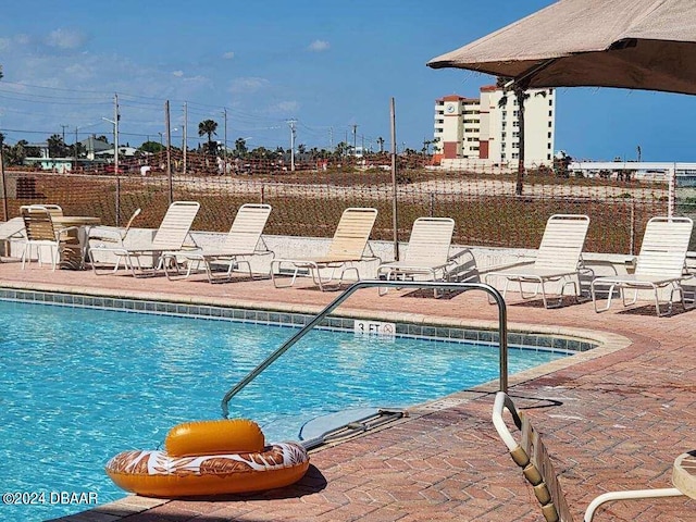 pool with fence and a patio