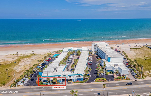 birds eye view of property with a water view and a beach view