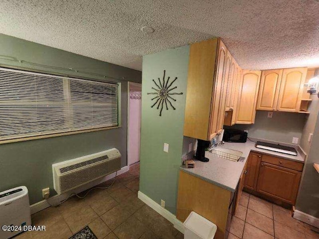 kitchen with light countertops, a textured ceiling, baseboards, and light brown cabinetry