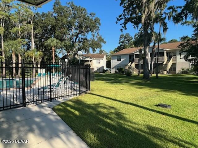 1600 Big Tree Rd Unit B3, South Daytona, FL 32119 - view of yard with a community pool, fence, and a residential view