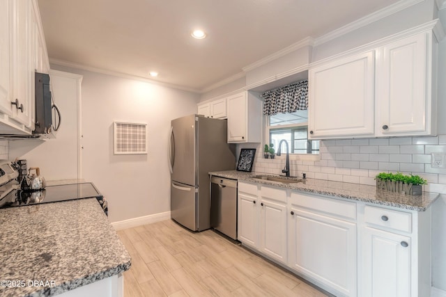991 Dawson Dr, Deltona, FL 32725 - kitchen with appliances with stainless steel finishes, a sink, white cabinetry, backsplash, and ornamental molding