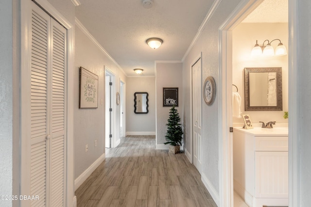 991 Dawson Dr, Deltona, FL 32725 - corridor featuring crown molding, a textured ceiling, light wood-type flooring, a sink, and baseboards